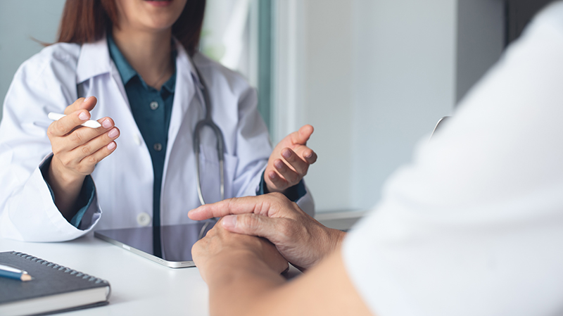 A patient talking to his doctor before his colon removal surgery